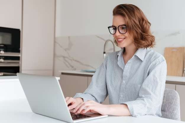 elegant smiling woman glasses striped shirt using laptop computer while siting table