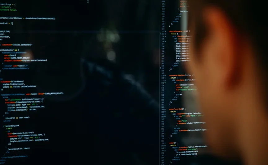 Close-up of a person looking at a computer screen displaying lines of code. The code is written in various colors, indicating syntax highlighting. The image focuses on the programming process, emphasizing technology and software development at a full stack web development agency.