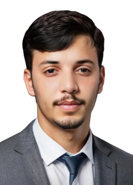 A portrait of a young man with short dark hair and a well-groomed beard, wearing a formal gray suit and a white shirt with a blue tie. He has a confident expression and is standing against a solid black background, emphasizing his professionalism. The lighting highlights his facial features and gives a polished look, perfect for a business or corporate context. He is a wordpress developer at zacoders software company that offer marketing and development services.